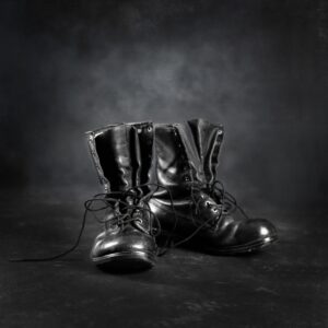 Black leather boots still life on neutral ground