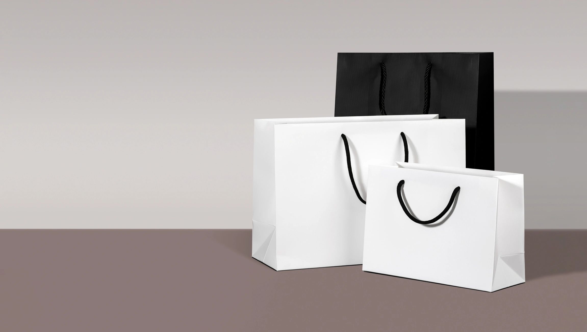 Minimal black and white shopping bags representing premium packaging